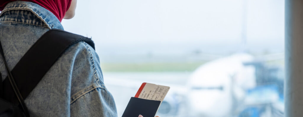Person looking at skies of opportunity with visa in hand